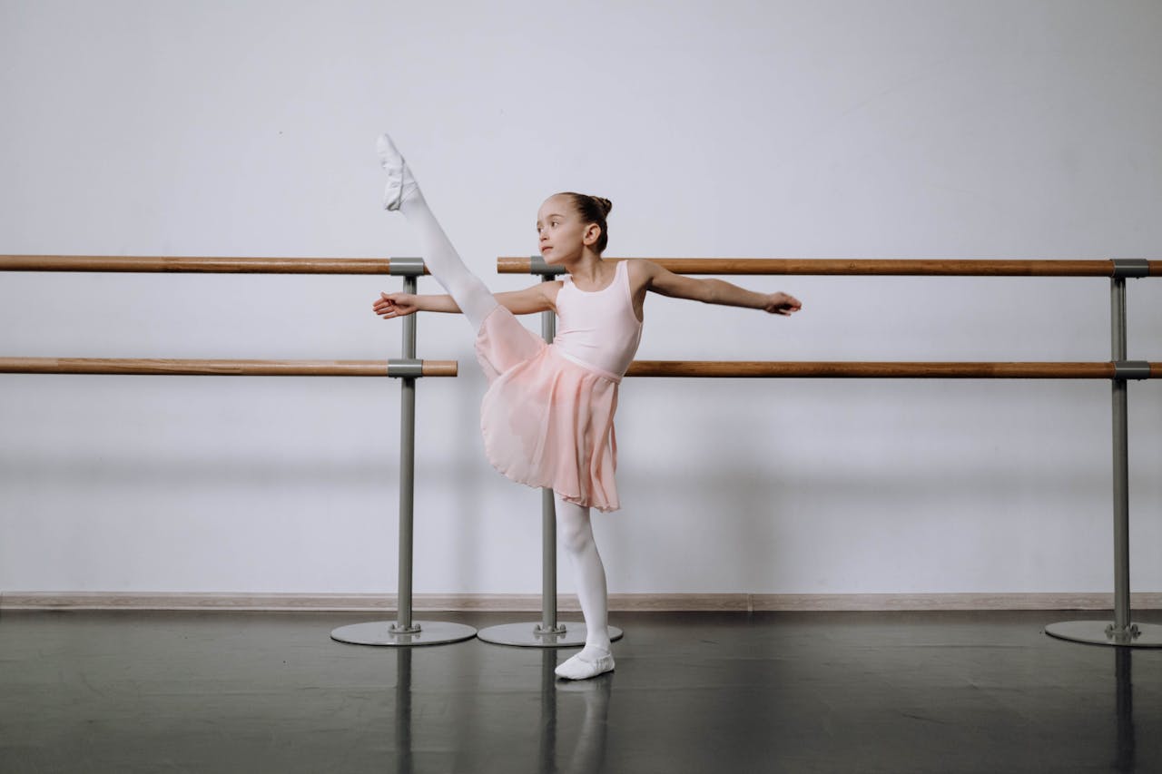 Crafting Captivating Headlines: Your awesome post title goes here A young girl practicing ballet stretches at a studio, showcasing flexibility and grace.